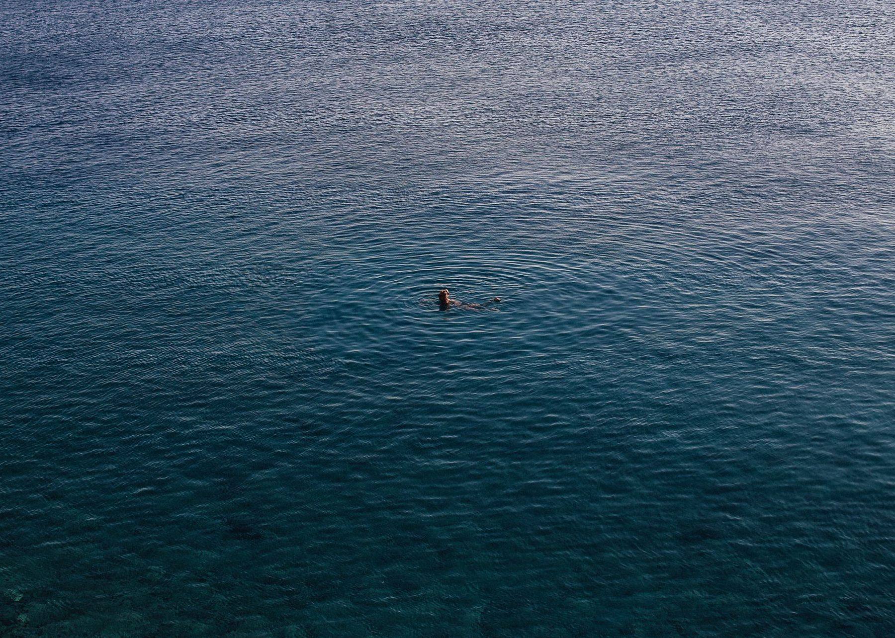 Lone swimmer in calm open water