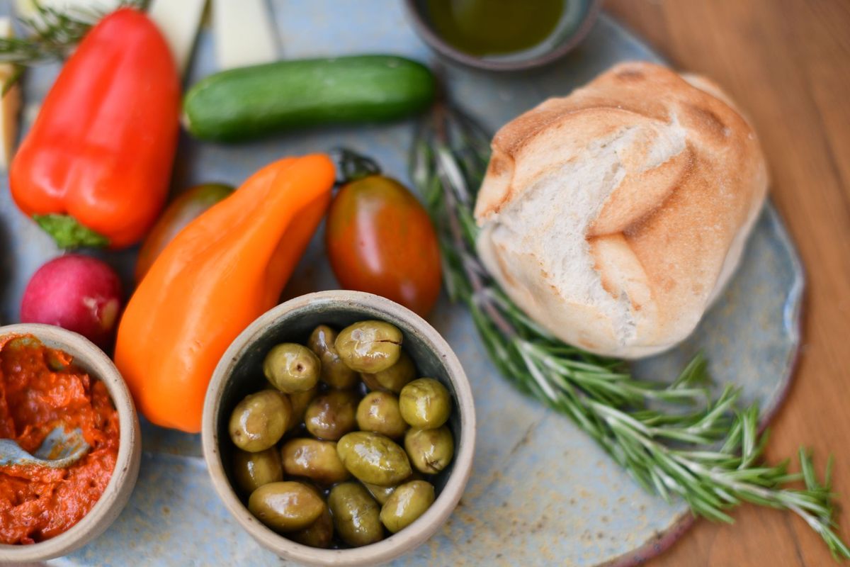 Mediterranean table with olives, vegetables, and rosemary