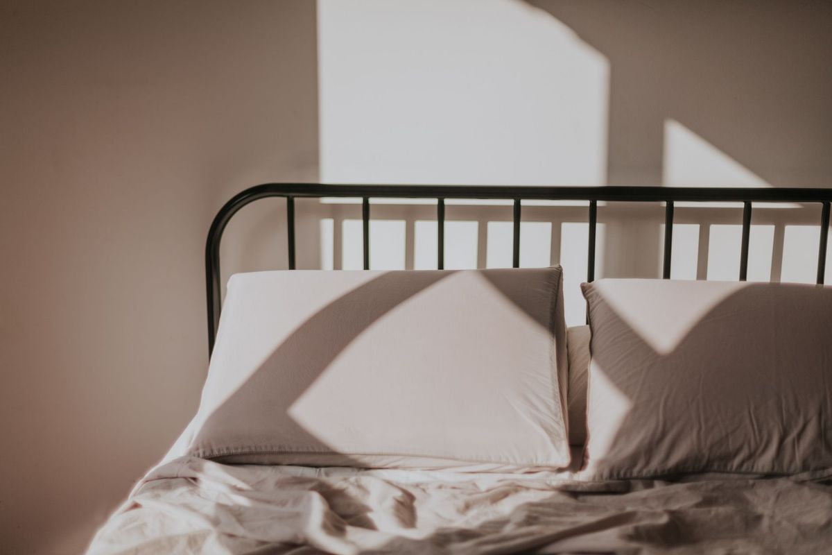 Morning light across a neatly made bed